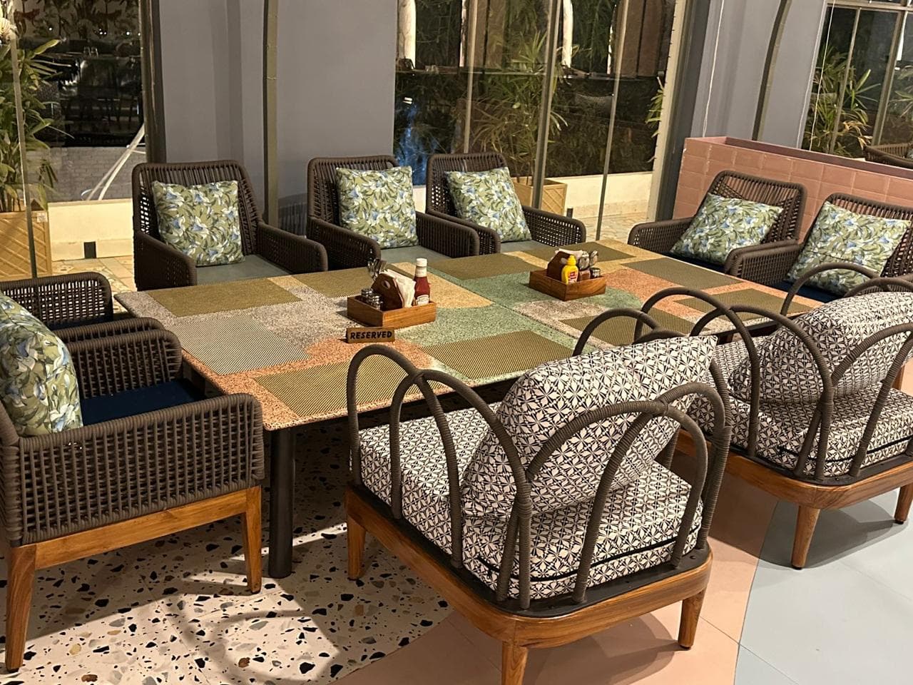 Cozy lounge seating with cushioned rattan chairs and a patchwork-style table.
