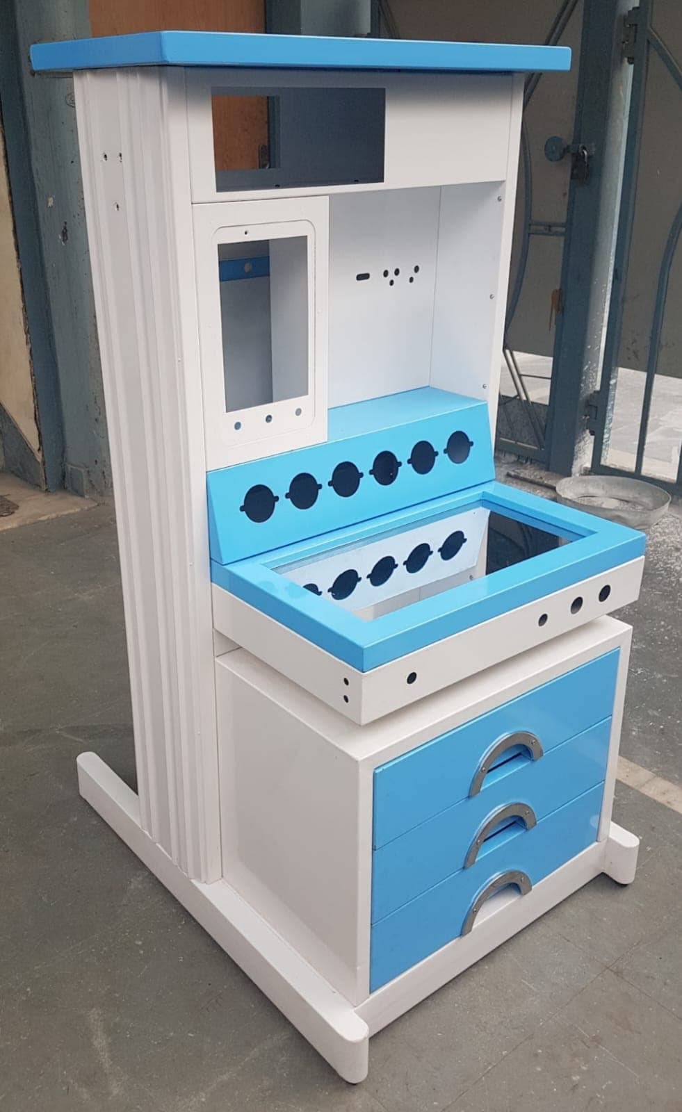 A white and blue anesthesia trolley with multiple compartments, drawers, cutouts for equipment, and a sturdy base.