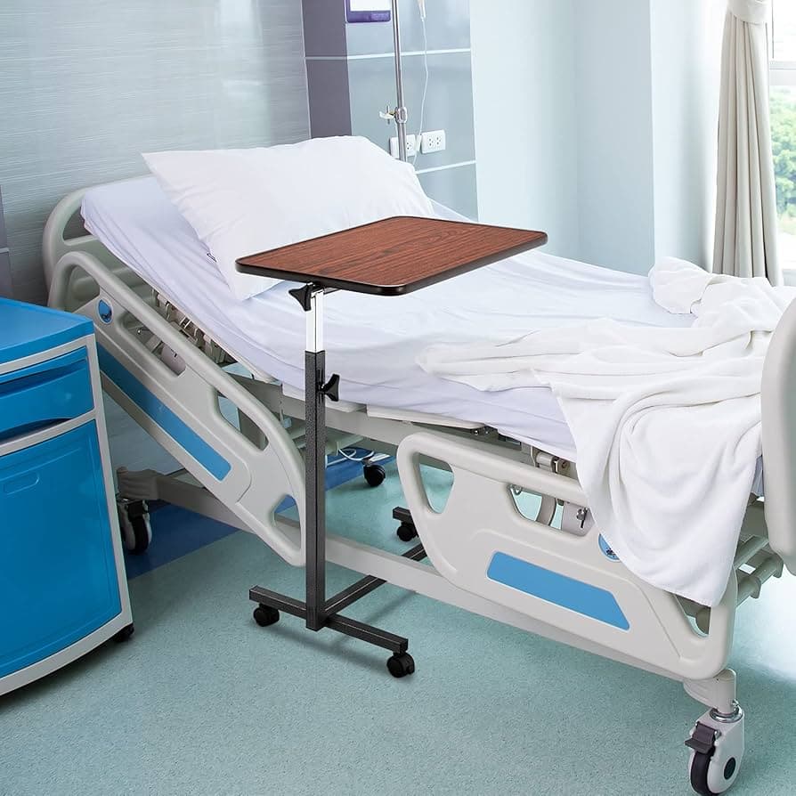 A hospital bed with white linens, an adjustable overbed table with a wooden surface, and a blue bedside cabinet in a clinical setting.