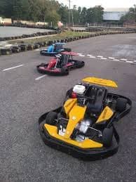 Three colorful go-karts parked on a racing track near the starting line.