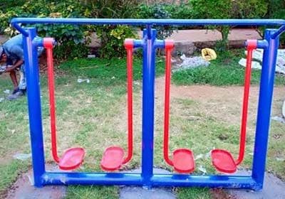 Outdoor double stepper fitness equipment with a blue frame and red foot pedals, designed for cardio and lower body exercises.